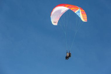 Paragliderler parlak mavi gökyüzünde, eğitmen ve acemi ikili. Aktif yaşam tarzı. Aşırı dinlenme.