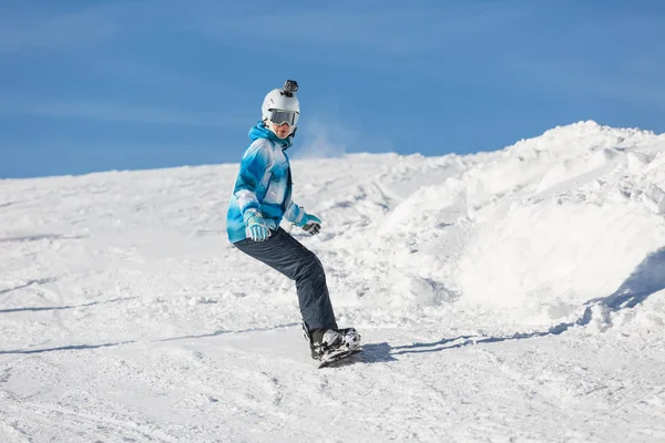 一个女孩骑在雪地上的雪板上 户外活动 在山上度假 — 图库照片