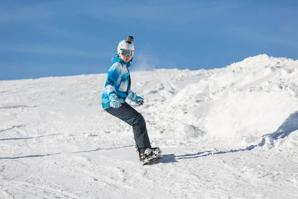 Kar yamacında snowboard süren bir kız. Açık hava aktivitesi. Dağlarda tatil..