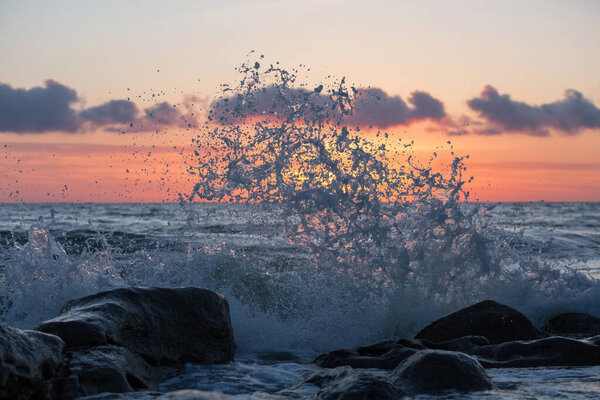 Море бьется о скалы своими волнами
.