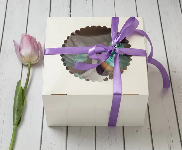 A box of cupcakes tied with a ribbon.