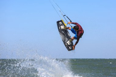Uçurtmacı deniz dalgalarına atlıyor. Sucullar.