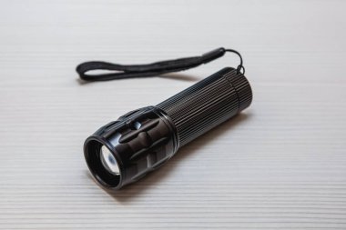 Beyaz masada siyah el feneri. Aydınlatma aygıtı.