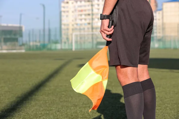 Hakem yardımcıları bir futbol maçı sırasında kenarda bayrak sallıyor. Futbol hakemi..