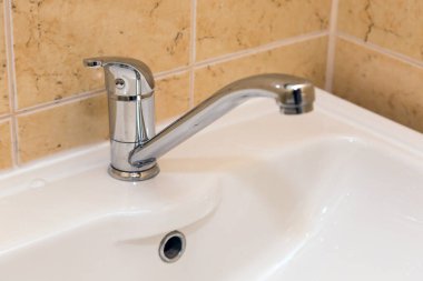 Krom vinç seramik lavabo banyo üzerinde Kapat.