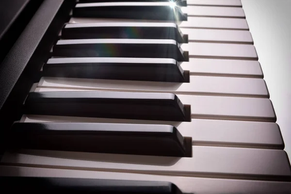 Electronic piano keyboard in shade with shine elevated side view — Stock Photo, Image