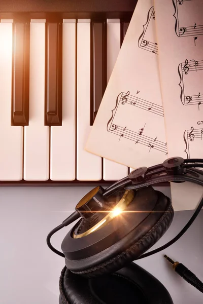 Electronic piano keyboard with headphones and sheet music top — Stock Photo, Image