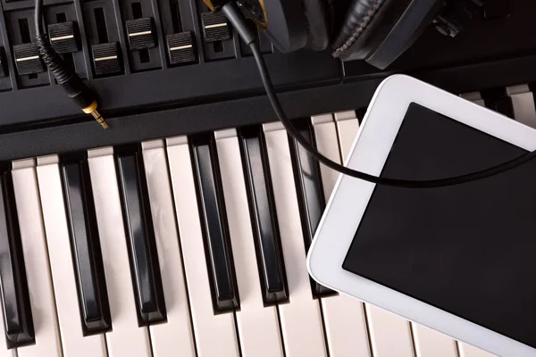 Piano eletrônico com fones de ouvido e tablet em estúdio vista superior — Fotografia de Stock