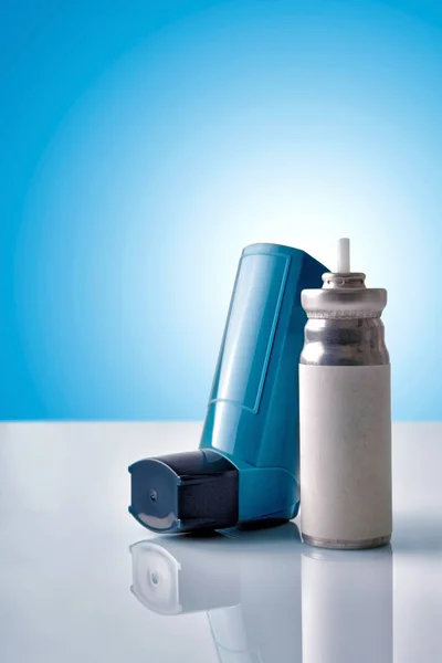 Cartridge en blauw geneeskunde inhalator met blauwe achtergrond front v — Stockfoto