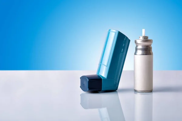 Κασέτα και μπλε συσκευή εισπνοής φαρμάκου με εμπρόσθιο v μπλε φόντο — Φωτογραφία Αρχείου