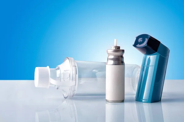 Cartridge inhaler and inhalation chamber with blue background fr — Stock Photo, Image
