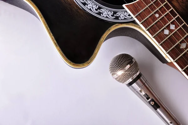 Guitare acoustique et microphone isolés sur table blanche vue du dessus — Photo