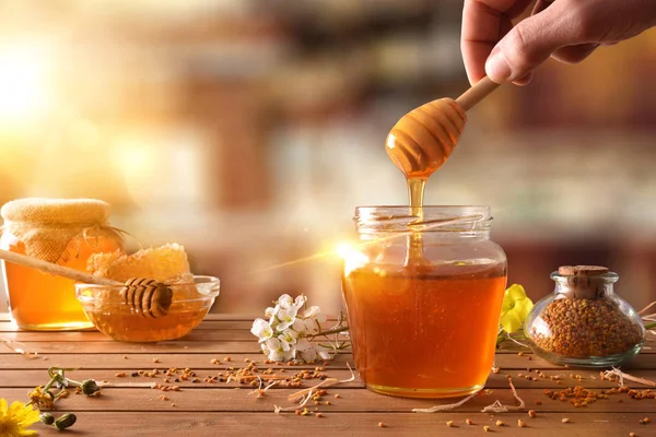 Hand mit dem Löffel, der Honig aus einem Glas Honig pflückt — Stockfoto