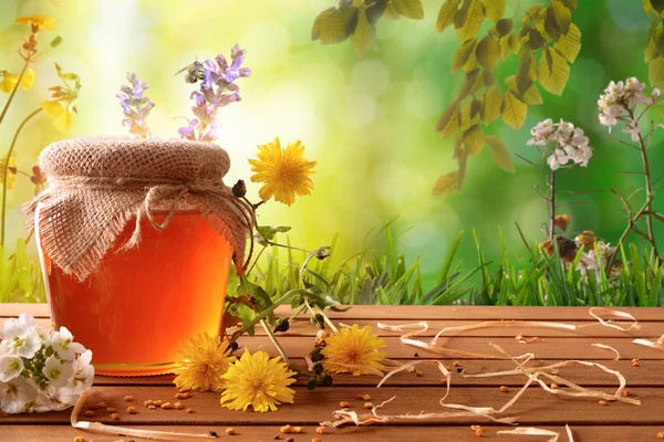 Méz pot, virágokkal, zöld természet háttérrel — Stock Fotó