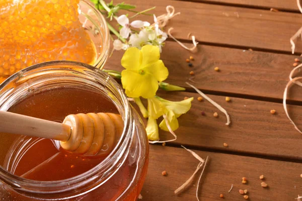 A fa asztal emelkedett makró méhsejt méz jar — Stock Fotó