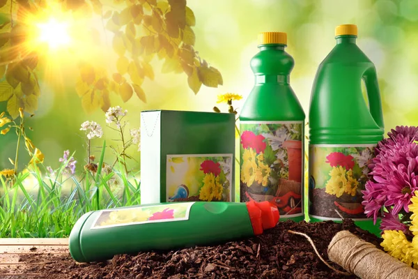 Bottles and containers of gardening products in nature with sunl