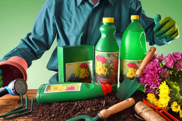 Trabajador mostrando botellas y recipientes de productos de jardinería —  Fotos de Stock