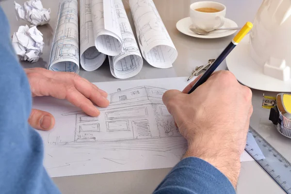 Construction engineer het tekenen van een huis op zijn Bureau close-up — Stockfoto