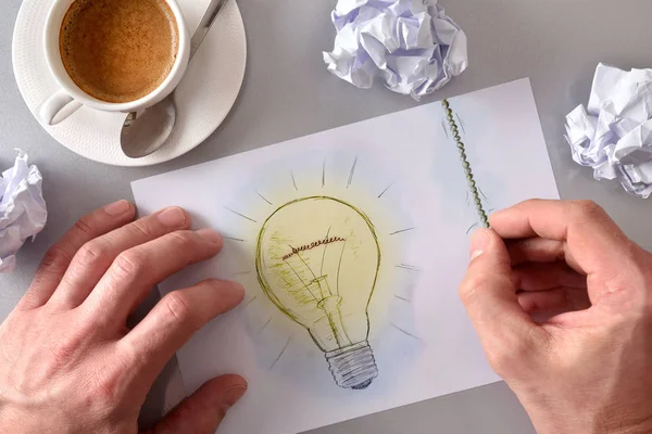 Idea concept man lighting a light bulb drawn on sheet