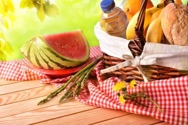 Piknik alanında yükseltilmiş masasına yemek ile hasır sepet