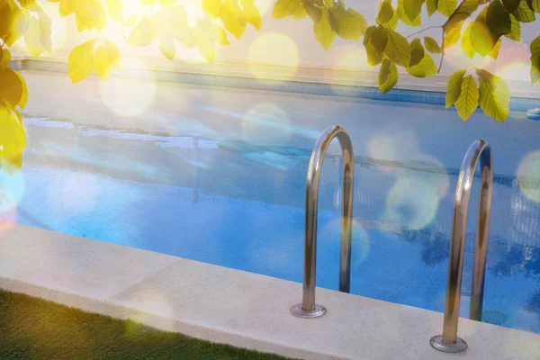 Escalera de piscina en piscina con hojas y sol —  Fotos de Stock