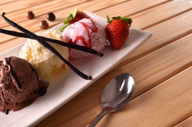 Üç top dondurma farklı tatlar üzerinde ahşap masa yükseltilmiş