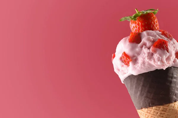 Конус мороженого со вкусом клубники розовый фон — стоковое фото