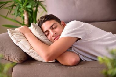 Adam evde minderler için tutunmuş bir kanepede uyuklayan