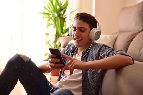 Έφηβος κάθεται στο πάτωμα χρησιμοποιώντας ένα smartphone στο σπίτι κινηματογράφηση σε πρώτο πλάνο — Φωτογραφία Αρχείου
