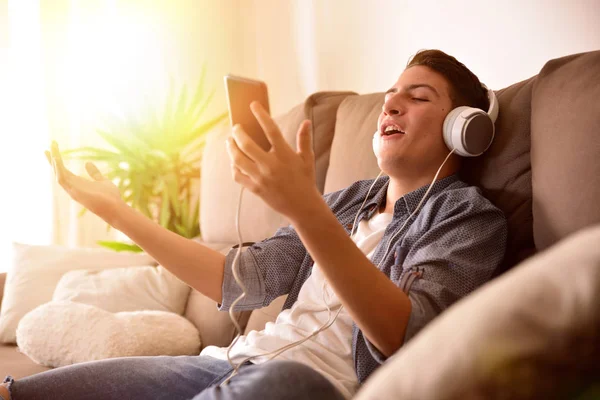 Tizenéves, a mobil, otthon a fotelben ülve énekel — Stock Fotó