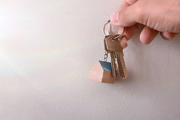 Hands hanging keys on a hook on the wall — Stock Photo, Image