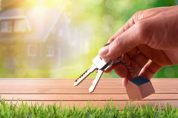 Hands with home keys on table on nature purchase concept — Stock Photo, Image