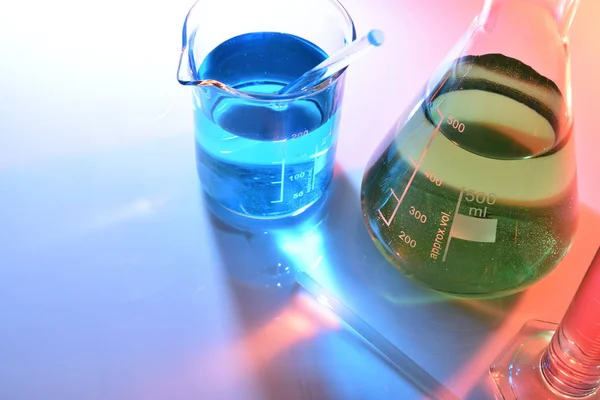 Лабораторные стеклянные химические контейнеры с цветным повышенным обзором — стоковое фото