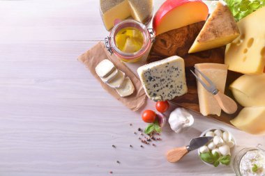 Beyaz ahşap bir masa üzerinde sunulan peynir türleri