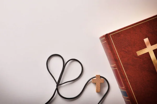 Biblia con colgante en forma de cruz y un cordón en forma de corazón — Foto de Stock