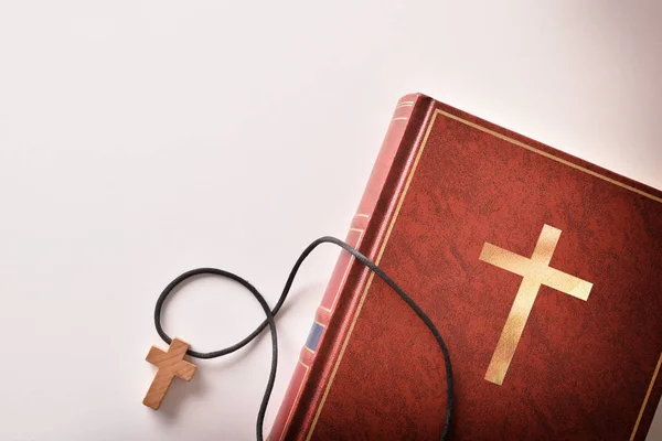 Библия на стороне с крестообразным кулоном — стоковое фото