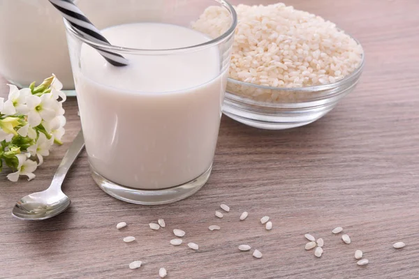 Рисовое молоко и рис в контейнерах на кухне возвышенный вид — стоковое фото