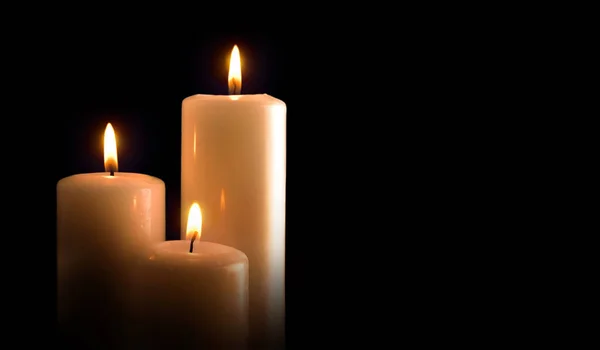 Three burning candles isolated black front view — Stock Photo, Image