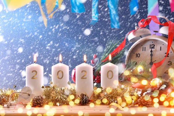 新年を祝うお祝いのテーブルの上のろうそくと時計2020 — ストック写真
