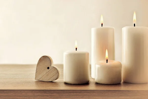 带有燃烧的蜡烛和木制桌子上的心的复古背景 — 图库照片