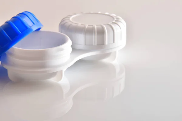 Contactlens kast open gereflecteerd op witte glazen tafel — Stockfoto