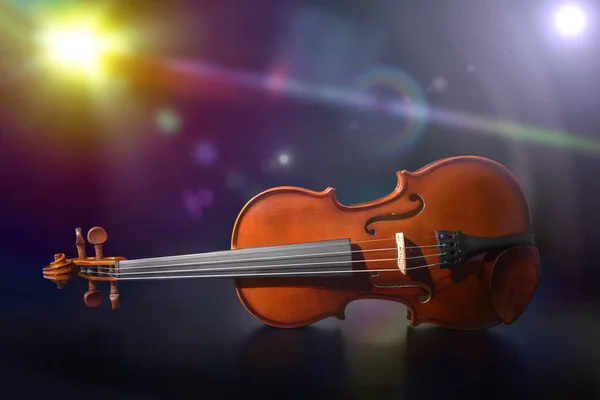 Violín sobre mesa de madera negra en el escenario con luces de colores —  Fotos de Stock