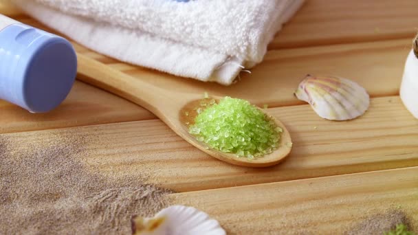Mão deixando concha do mar na mesa em torno de produtos de talassoterapia — Vídeo de Stock