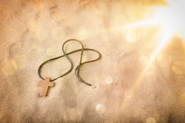 Crucifix Moitié Enterré Dans Sable Avec Des Paillettes Bokeh Composition — Photo