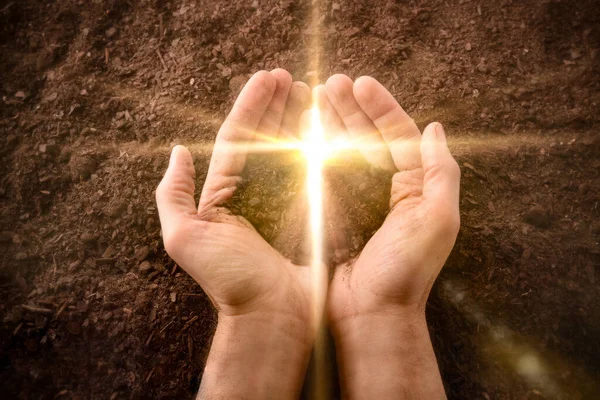 Hands Together Small Mound Earth Golden Flash Shape Cross Background — Stock Photo, Image