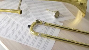 Dönen manzara parçalanmış altın trombon ve ahşap masada puanlar