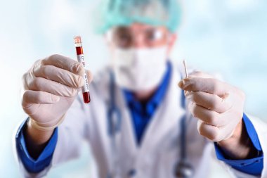Doktor, kovid 19 tüp testi ve koruyucu eldivenli örnek örneği gösteriyor.