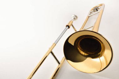 Beyaz bir masanın üzerindeki trombon çanının görüntüsü. Manzara yükseldi. Yatay bileşim.