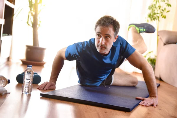 Oturma Odasında Yerde Dambıllarla Bacak Egzersizi Yapan Bir Adam — Stok fotoğraf