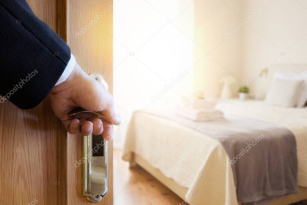 Hotel commuter opening the door of a sunny room